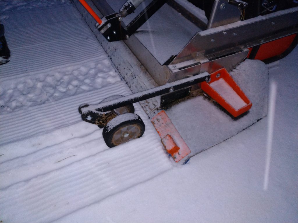 close up image of grooming machine grooming the snow