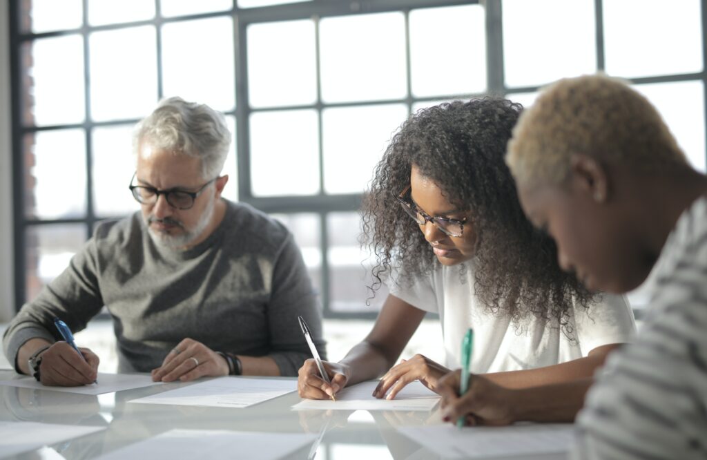 three people of different races working on a project together