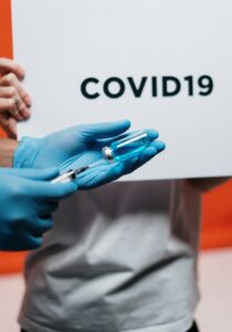 gloved hand filling syringe with Covid-19 vaccine