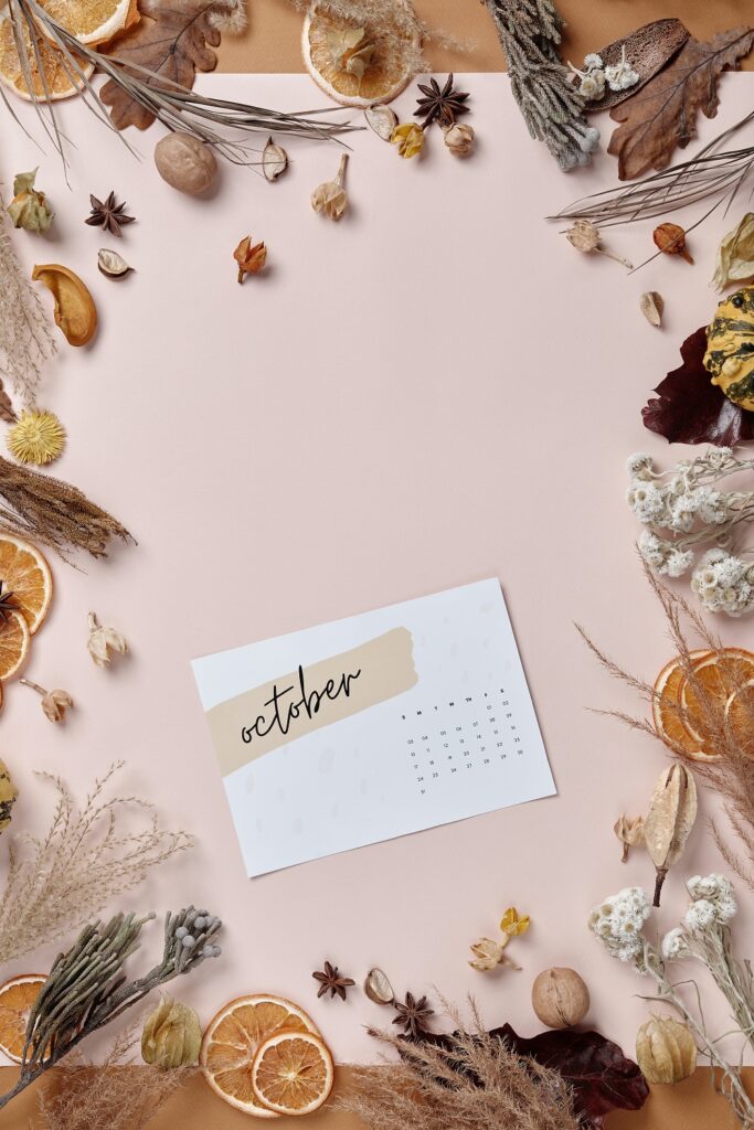 decorative image - dried herbs and flowers along the border with an October calendar centered in the shot.