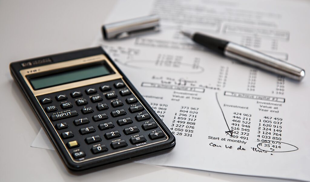 image of a calculator, a pen and a print out of a budget