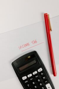 calculator, pen and words "income tax"