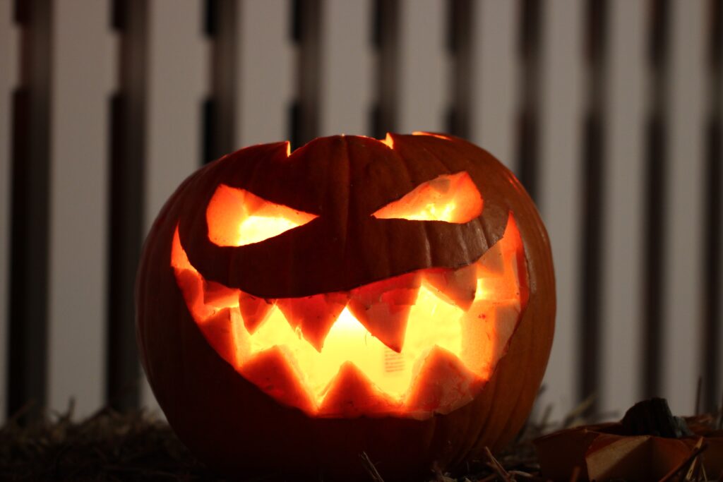 photo of a carved pumpkin lit up with a candle inside