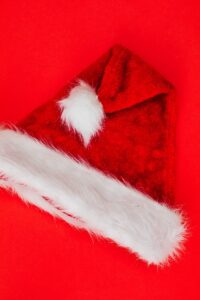 a photo of a red and white santa claus hat on a red background.