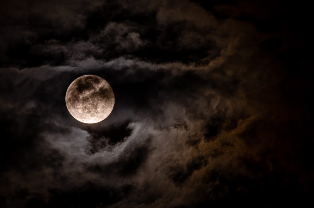 photograph of the full moon with some cloud cover