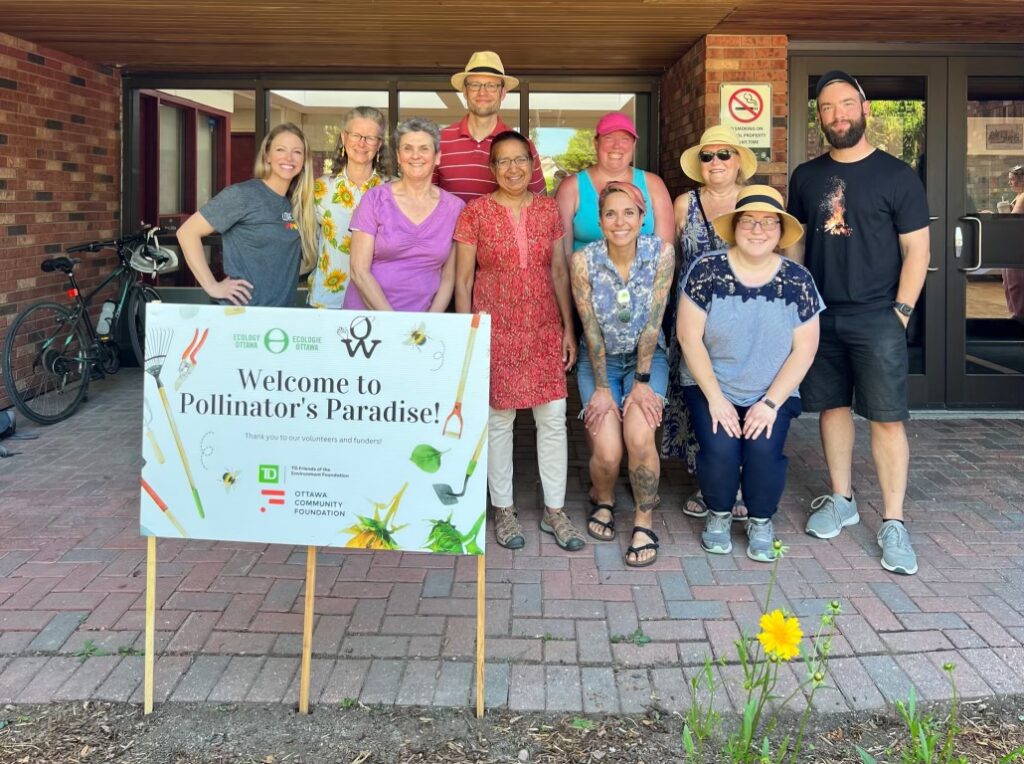 The enviro committee standing in front of Orleans Wood Elementary School in celebration of the Pollinator's Paradise sign.