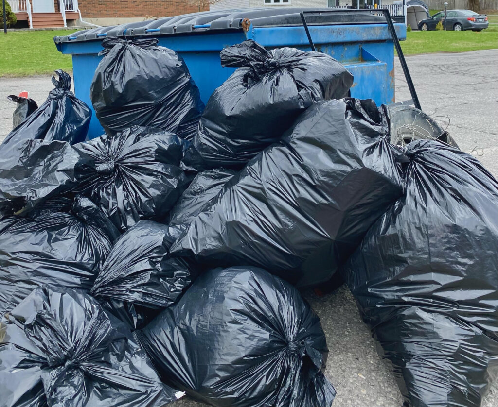 A photo of the final giant pile of garbage bags filled with trash from the spring clean up.